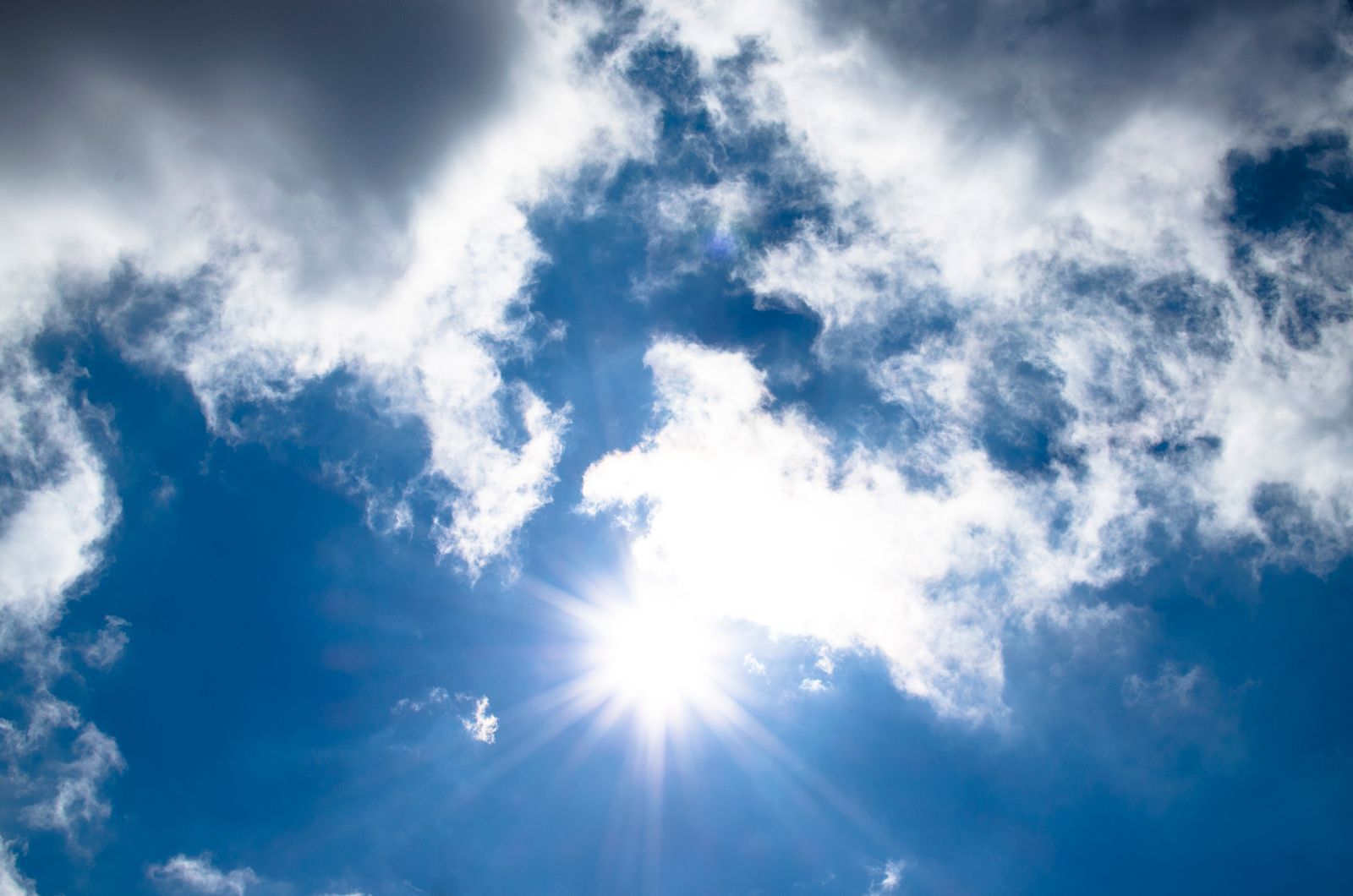 Blazing summer sun bursting through a bright blue sky on a hot day